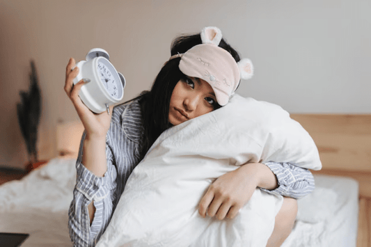 Girl holding a clock in bed